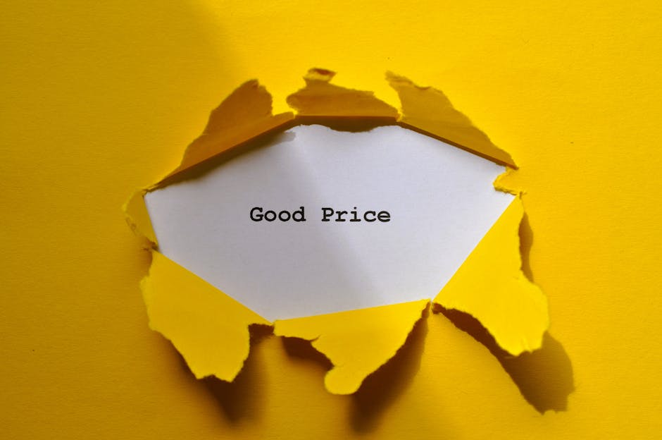 A close-up view of a hole in a yellow piece of torn paper or cardboard, revealing a white inner layer with the words 'Good Price' typed in black, typewriter-style font. The torn edges of the yellow ma